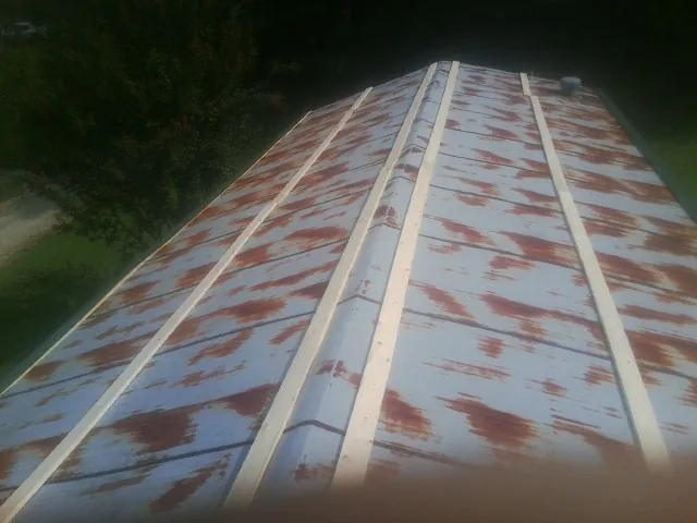 Rusted metal roof panels with new wood purlins before replacement — Storm Damage Roof Repair in Mc David by Roofing Brothers