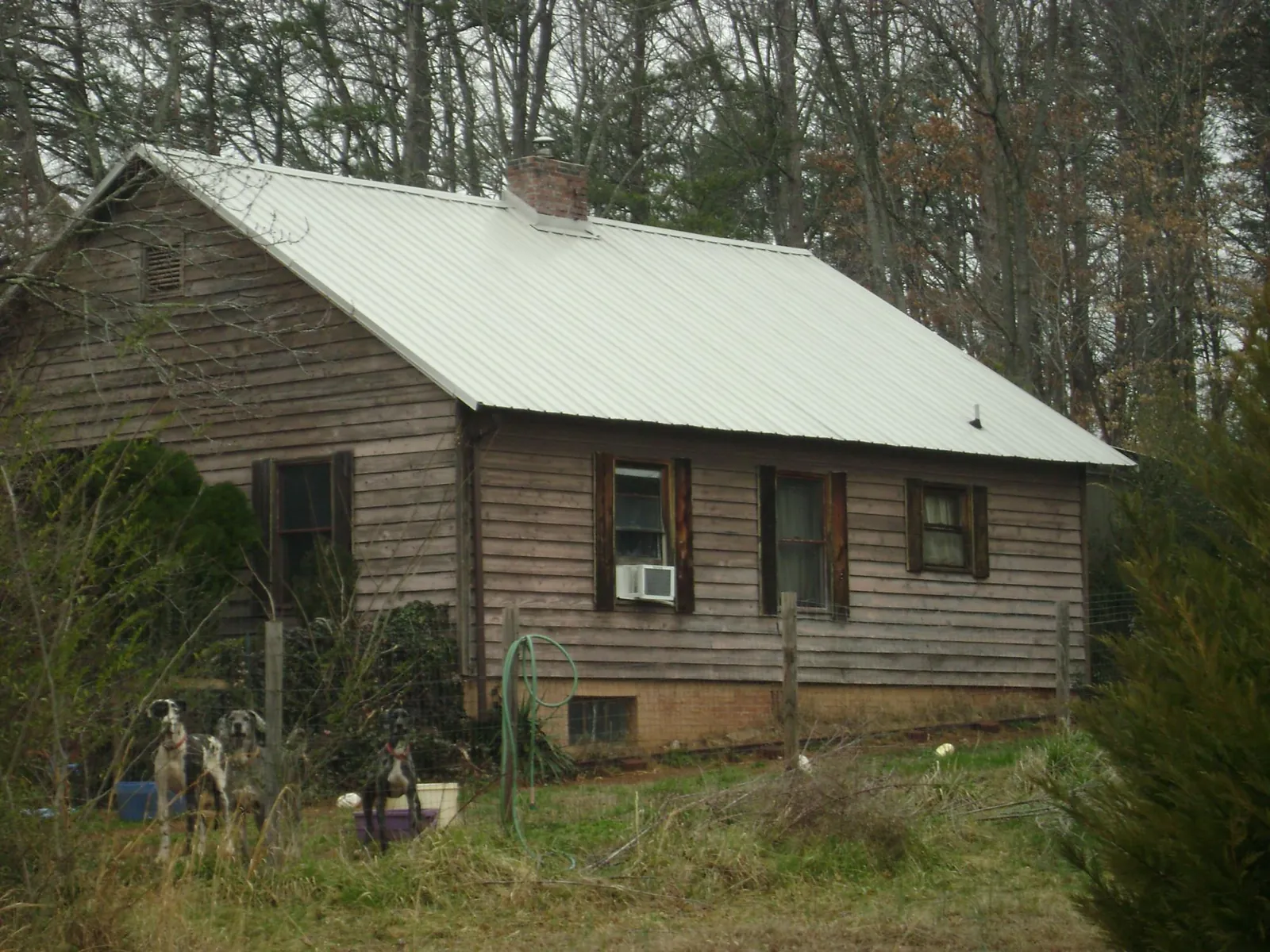 White metal roof on an old wood sided farmhouse, from a Metal Roof Installation job in Mc David